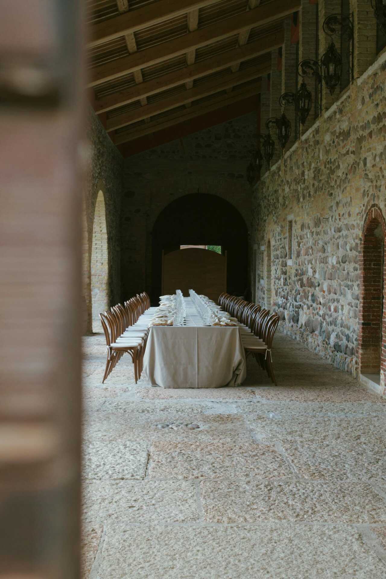 Long table setup in a historic Italian venue, ideal for events and gatherings.