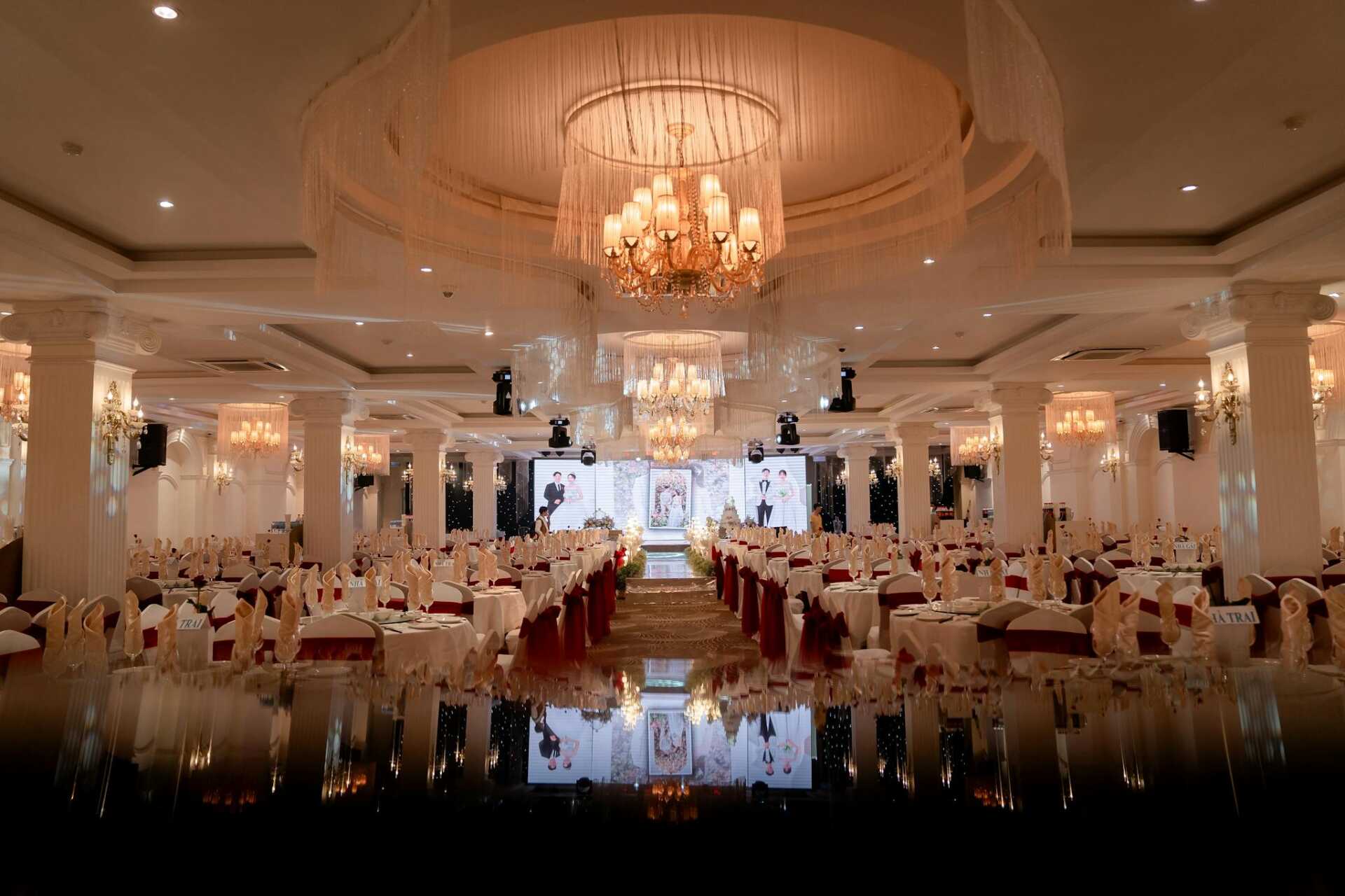 Luxurious ballroom beautifully arranged for a grand evening event, with chandeliers illuminating the decor.
